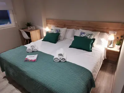 a bedroom with a bed with green and white pillows at Km101 in Baamonde