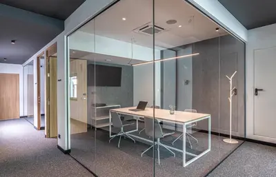 an office with glass walls and a table with a laptop at Hotel Forum Ceao in Lugo
