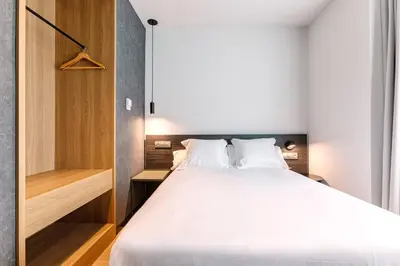 a bedroom with a large white bed and a closet at Hotel Forum Ceao in Lugo