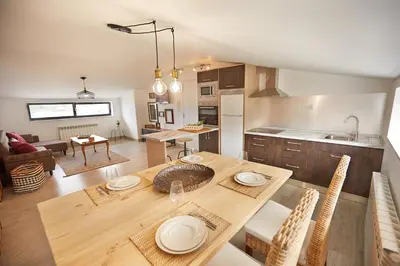 a kitchen and living room with a wooden table and chairs at Ático con maravillosas vistas in Viveiro