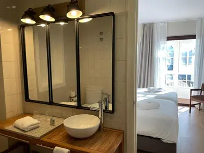 a bathroom with a sink and a bed and a mirror at Hotel San Marcus in Porta