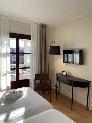 a bedroom with a bed and a desk and a window at Hotel San Marcus in Porta