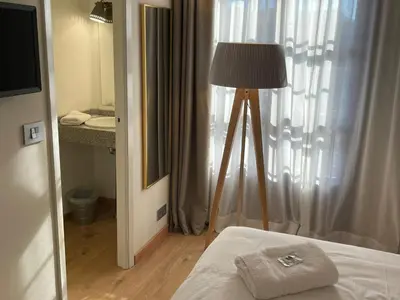 a room with a bed and a lamp and a window at Hotel San Marcus in Porta