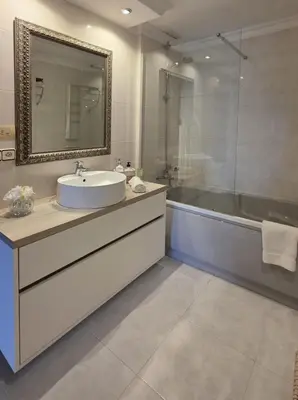 a bathroom with a sink and two bottles of wine at Centro pueblo Santa Cruz - Oleiros - A Coruña in Santa Cruz de Oleiros