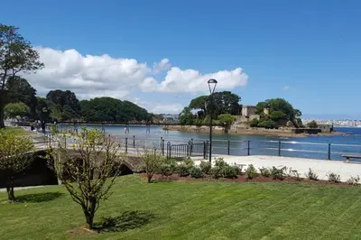 a beach with people on it next to the water at Centro pueblo Santa Cruz - Oleiros - A Coruña in Santa Cruz de Oleiros