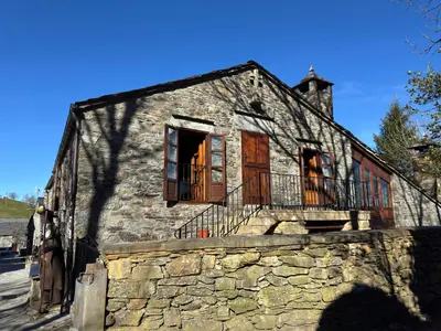 a bedroom with two beds and a stone wall at Casa O Cebreiro in O Cebreiro