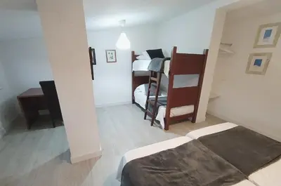 a small room with two bunk beds and a bed at Finca Segade in A Estrada