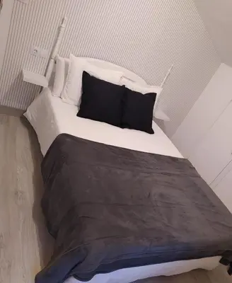 a large bed with black and white sheets and pillows at Finca Segade in A Estrada