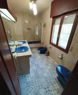 a bathroom with two sinks and a blue toilet at Finca Segade in A Estrada