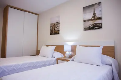 a hotel room with two beds with white sheets at Laros Pios Alojamiento 2 in Villalba