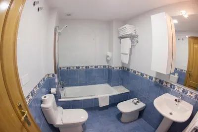 a bathroom with a toilet and a tub and a sink at Laros Pios Alojamiento 2 in Villalba