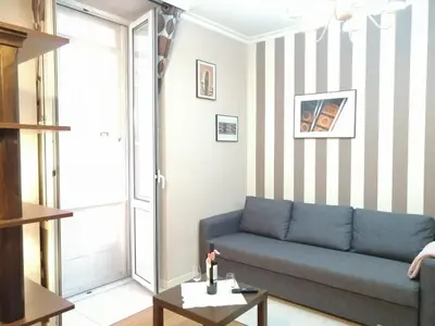 a living room with a blue couch and a striped wall at BERAMAR APARTMENT in Viveiro