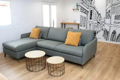 a living room with a blue couch and two tables at Tu Rincón en Compostela in Santiago de Compostela