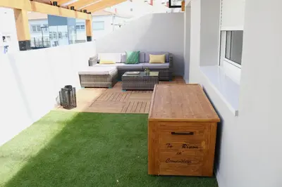 a patio with a couch and a table and grass at Tu Rincón en Compostela in Santiago de Compostela