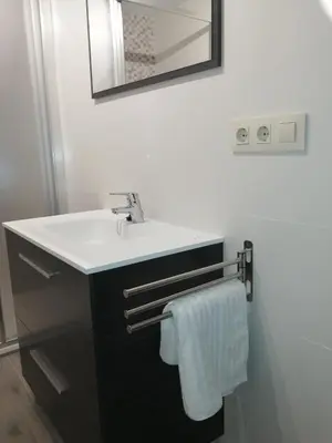a bathroom with a white sink and a mirror at Apartamento A Fabrica in Santiago de Compostela