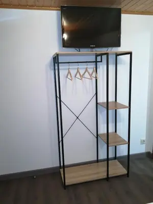 a glass display case with hangers and a television on top at Apartamento A Fabrica in Santiago de Compostela