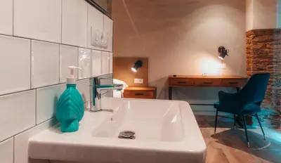 a bathroom with a sink with a green bottle on it at Pensión A Marronda in Baleira
