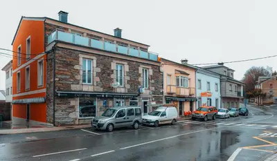 a city street with cars parked in front of buildings at Pensión A Marronda in Baleira