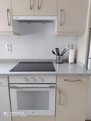 a kitchen with white cabinets and a stove top oven at Piso de alquiler en Tapia de Casariego in Tapia de Casariego