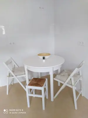 a white table and chairs with a bowl on top at Piso de alquiler en Tapia de Casariego in Tapia de Casariego