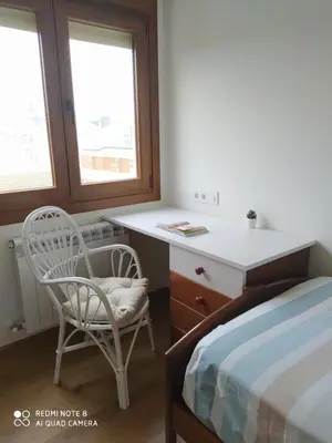 a bedroom with a desk and a chair next to a bed at Piso de alquiler en Tapia de Casariego in Tapia de Casariego