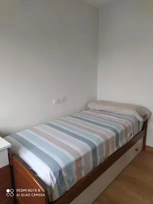 a bed in a room with a striped mattress at Piso de alquiler en Tapia de Casariego in Tapia de Casariego