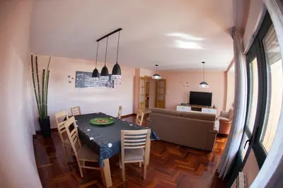 a dining room and living room with a table and chairs at Laros Pios Alojamiento 1 in Villalba