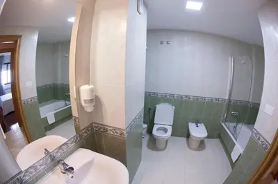 a bathroom with two toilets and a sink at Laros Pios Alojamiento 1 in Villalba