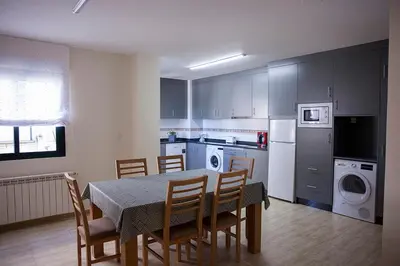 a kitchen with a table and chairs and a dining room at Laros Pios Alojamiento 1 in Villalba