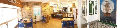 a room with a bar with blue chairs in it at Hotel A Falúa in Puentedeume