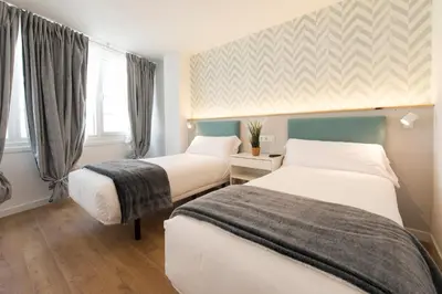 a hotel room with two beds and a window at Hotel A Falúa in Puentedeume