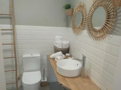 a bathroom with a sink and a toilet and mirrors at Hotel A Falúa in Puentedeume