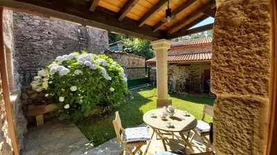 a patio with a table and chairs in a yard at A Casa dos Avós - Vilariño - A Coruña in Vilariño