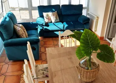 a living room with a blue couch and a table at Casa Sueño in Foz