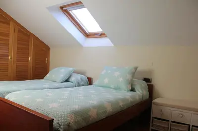 a bedroom with two beds and a skylight at Casa Sueño in Foz