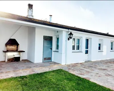 a white house with a fireplace in a yard at Casa Sueño in Foz