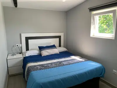 a bedroom with a bed with a blue comforter and a window at Casa rural La casilla de Ois-Betanzos-A Coruña in Coirós