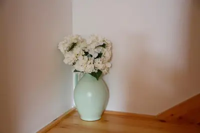 a white vase with white flowers in a room at Casa Muiño dos Frades in Lourenzá