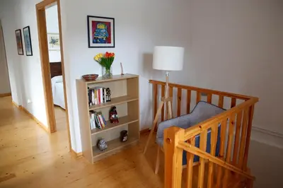 a room with a chair and a book shelf with books at Casa Muiño dos Frades in Lourenzá