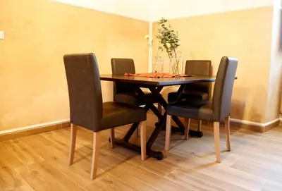 a dining room table with chairs and a vase of flowers at Casa Muiño dos Frades in Lourenzá
