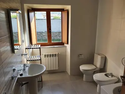 a bathroom with a sink and a toilet and a window at Casa Muiño dos Frades in Lourenzá