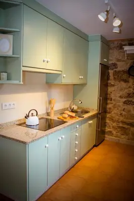 a kitchen with blue cabinets and a sink at Miña Nai, Casa Rural in Lalín