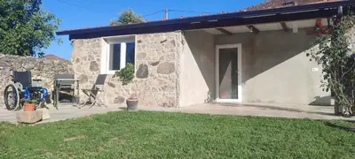 a stone house with a patio and a yard at CASA 