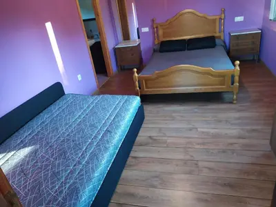 two beds in a room with purple walls and wooden floors at CASA 
