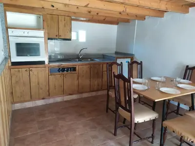 a kitchen with wooden cabinets and a table with chairs at CASA 