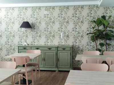 a dining room with green cabinets and pink chairs at Vía Sacra in Porta