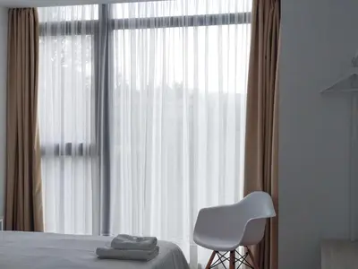 a bedroom with a bed and a white chair and a window at Vía Sacra in Porta