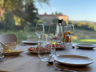 a wooden table with wine glasses and food on it at Vía Sacra in Porta
