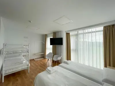 a hotel room with two beds and a television at Vía Sacra in Porta