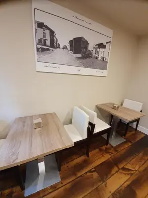 a dining room with two tables and a picture on the wall at Albergue Casa Cuartel in Fonsagrada